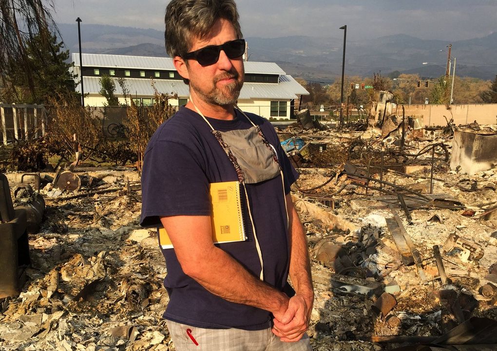 Scott Balcom, of Talent, Oregon, stayed through much of the Almeda Fire in a failed effort to save his home. The Empowered Life Church, in the background, survived due to its fire-resistant construction. (Hal Bernton / The Seattle Times)