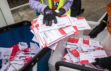 Cheral Bogar, left, and Chris Rudolph, right, of King County Elections, unload a full ballot drop box on Election Day for the 2018 Midterms Tuesday November 6 in downtown Burien, Washington. Bogar drives the ballot van, while Rudolph is a project program manager for King County Elections. 208408
