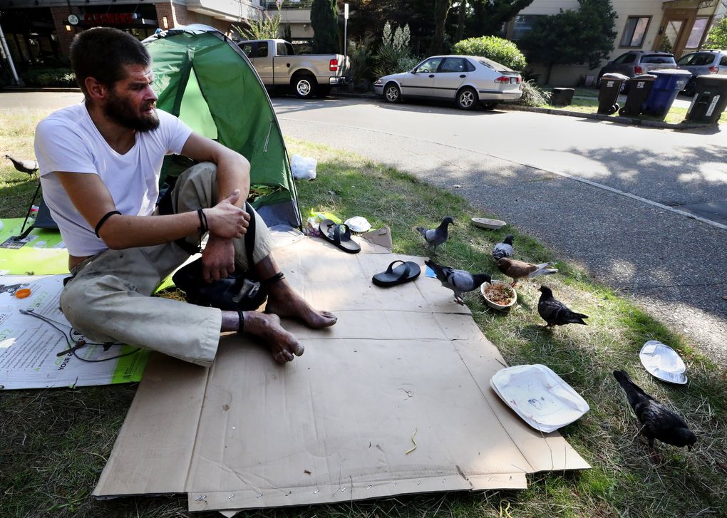 Dan Huntington says he’s been living on the street for 20 of his 35 years. Camped at East John and East 15th, he says the neighborhood doesn’t mind their presence and it’s safe. Pigeons are eating the remnants of his breakfast. The encampment is relatively clean with trash picked up by residents. Bathrooms are found in a couple of nearby stores. He says no navigation team has visited to talk to residents. (Alan Berner / The Seattle Times)