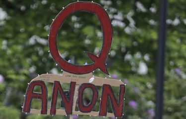 FILE – In this May 14, 2020, file photo, a person carries a sign supporting QAnon at a protest rally in Olympia, Wash. Facebook said Tuesday, Oct. 6, 2020, that it will remove Facebook pages, groups and Instagram accounts for â€œrepresenting QAnon.â€ (AP Photo/Ted S. Warren, File) NYSB261 NYSB261