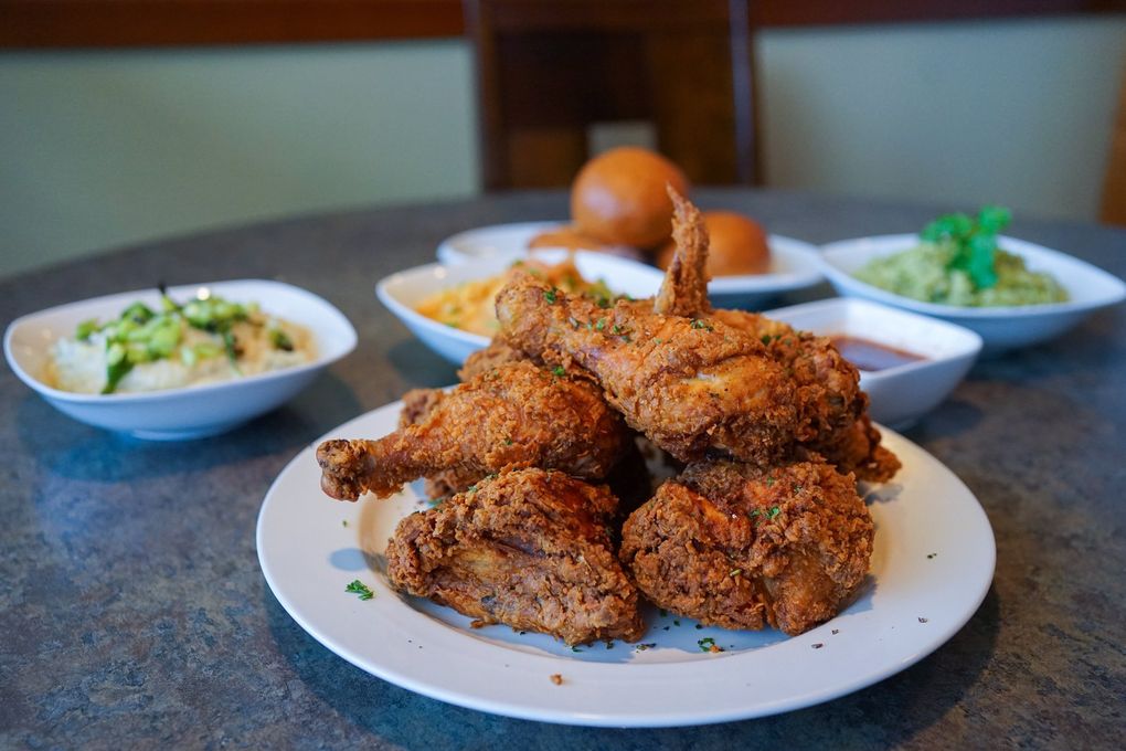 Seattle Times food critic Tan Vinh raves about the $50 Sunday family meal deal at Bar Dojo, which features eight pieces of organic Draper Valley fried chicken along with lumpy mashed potatoes with grilled green onions, kimchi macaroni and cheese, avocado rice and four dinner rolls and hot sauces. (Courtesy of Madeline Ingha)