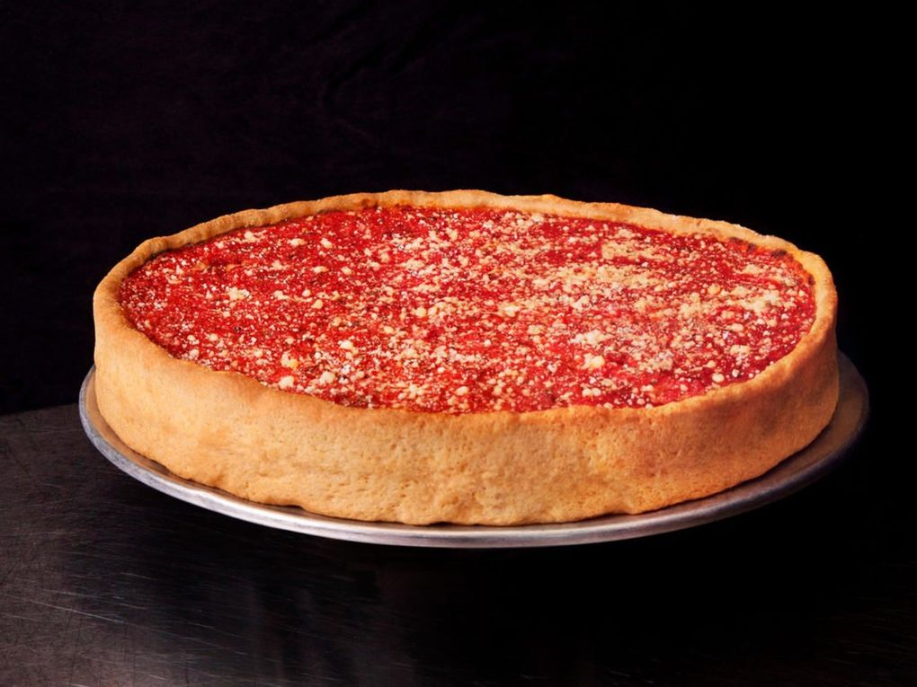 “The Original” pie at West of Chicago Pizza Company in West Seattle weighs 4.4 pounds, stuffed with fennel sausage, pepperoni, caramelized onions, red sauce and 20 ounces of mozzarella cheese. It’s dusted with Parmesan cheese to finish. (Courtesy of Monica Rodriguez)