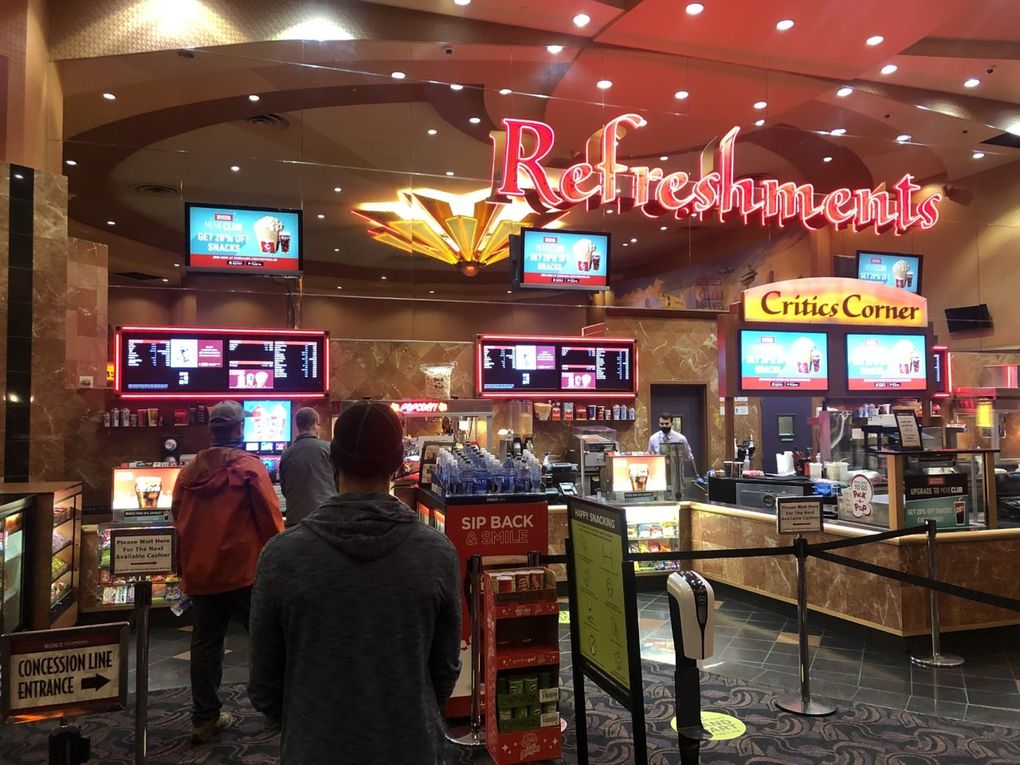 A handful of customers wait in line for refreshments at Cinemark Lincoln Square Cinemas in Bellevue last weekend. (Trevor Lenzmeier / The Seattle Times)