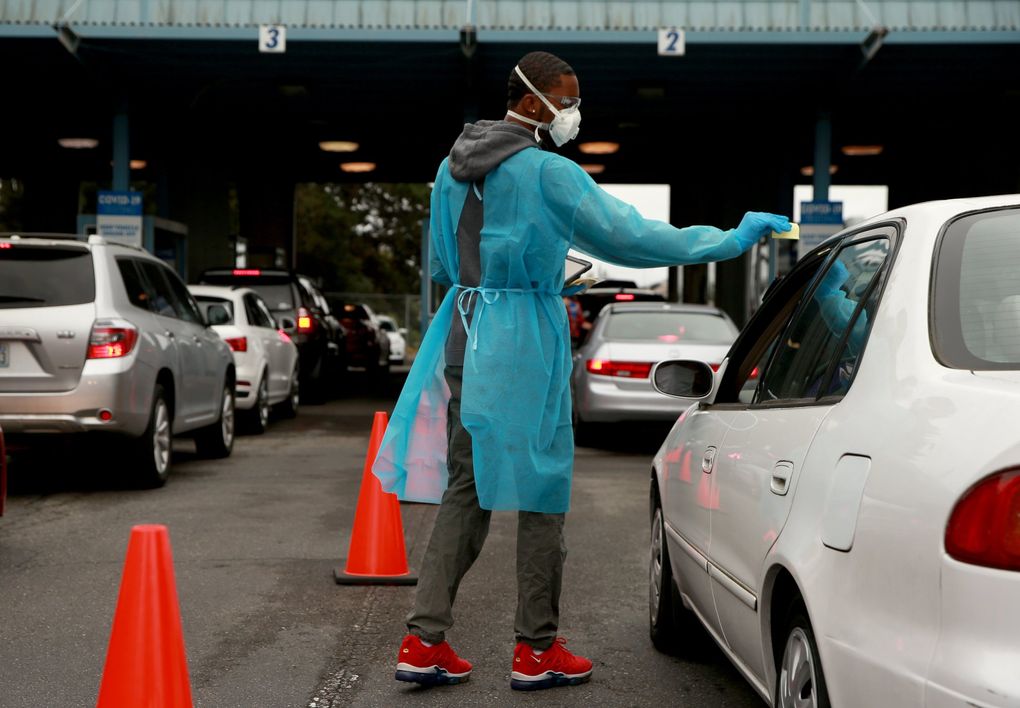 Registration technician André Grady checks in with community members for COVID-19 testing at the City of Seattle’s Testing Site on Aurora Avenue North. “I like to help people, calm people down in a stressful situation,” he says. “It feels good to give back to the community.” (Erika Schultz / The Seattle Times)