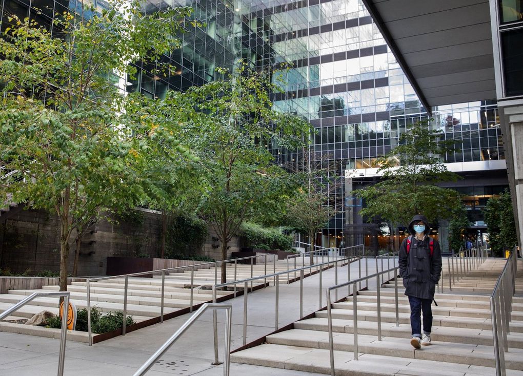 A lone person leaves an Amazon building in South Lake Union Wednesday, October 21, 2020. Amazon is extending its work-from-home plan through June of 2021. (Ellen M. Banner / The Seattle Times)