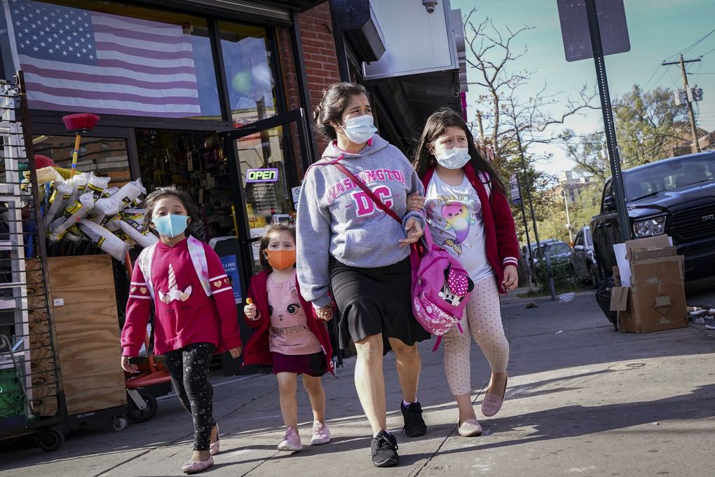 Pedestrians in masks pass a store on Thursday, Oct. 15, 2020, in the Far Rockaway neighborhood of the borough of Queens in New York. Research from the Institute for Health Metrics and Evaluation at the University of Washington shows the most effective — not to mention cheapest and easiest — way to reduce deaths is to increase the number of people wearing masks.(John Minchillo / The Associated Press)