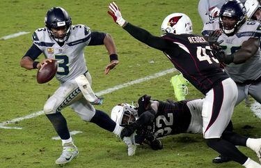 Seattle Seahawks quarterback Russell Wilson (3) escapes the reach of Arizona Cardinals strong safety Budda Baker (32) as outside linebacker Haason Reddick (43) pursues during the second half of an NFL football game, Sunday, Oct. 25, 2020, in Glendale, Ariz. (AP Photo/Ross D. Franklin) AZMY140 AZMY140