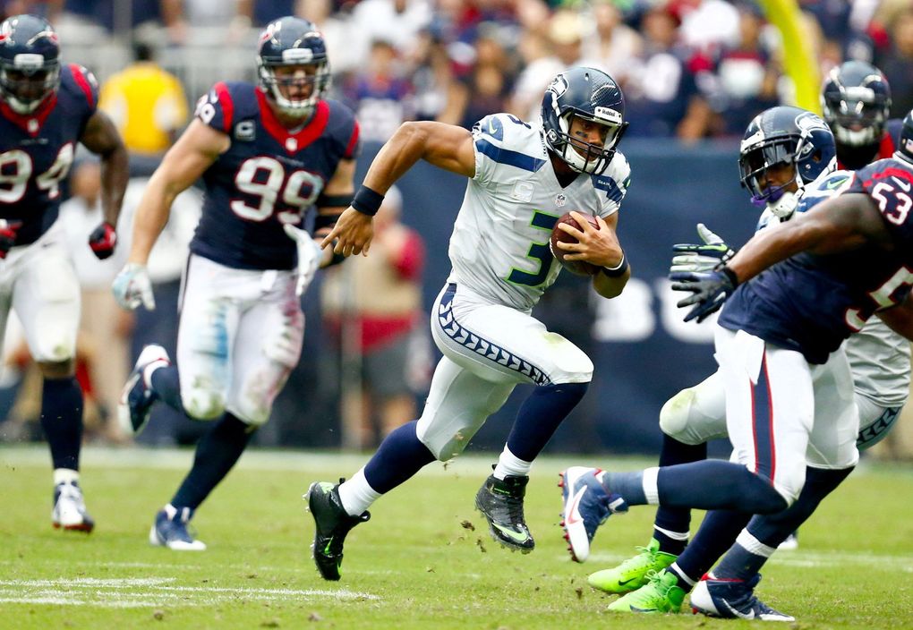 Seahawks quarterback Russell Wilson keeps the football against the Houston Texans in the second half at Reliant Stadium on Sept. 29, 2013, in Houston. Seattle won 23-20 in overtime. (John Lok / The Seattle Times)