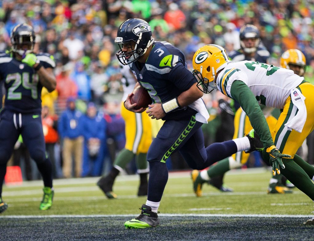 Seahawks quarterback Russell Wilson rushes a yard for a touchdown, cutting Green Bay’s lead to 5 during the fourth quarter in the NFC championship at CenturyLink Field on Jan. 18, 2015. (Dean Rutz / The Seattle Times)