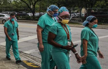 Medical workers outside of Jackson Memorial Hospital in Miami, on Wednesday, July 22, 2020. The virus is less concentrated than it was in the spring, when U.S. hospitalizations reached their previous high mark, but it is causing as many people as ever to fall seriously ill. (Saul Martinez/The New York Times)