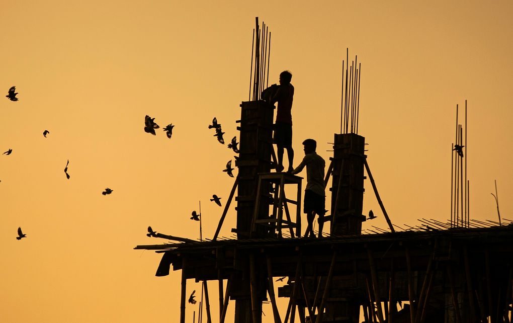 Indian laborers work at a building construction site in Gauhati, India, Monday, Oct. 19, 2020. (AP Photo/Anupam Nath)