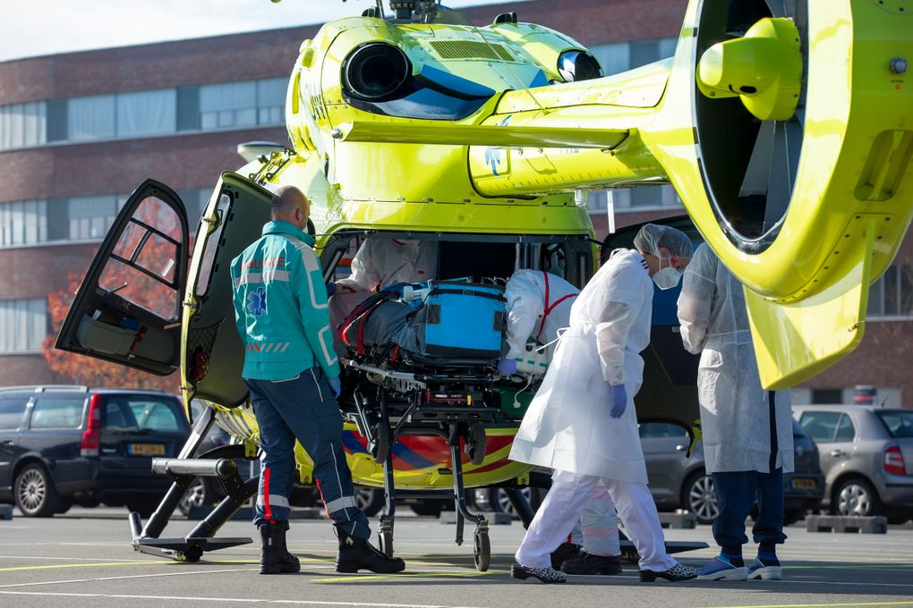 A COVID-19 patient is being carried into a helicopter at Flevoziekenhuis, or FlevoHospital, in Almere, Netherlands, Friday, Oct. 23, 2020. In the latest sign of the scale of the coronavirus pandemic sweeping across Europe, a helicopter is scheduled to start airlifting COVID-19 patients from the Netherlands to an intensive care unit in the German city of Muenster.(AP Photo/Peter Dejong)