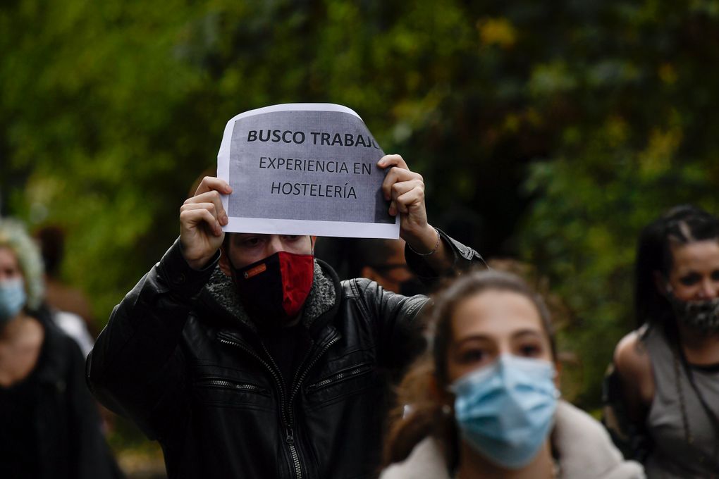 In Spain, which is now the first nation in Western Europe to reach 1 million coronavirus cases, a man holds up banner in support of hotel industry and the job reading,” I search for work”, in Pamplona, northern Spain, Wednesday. (AP Photo/Alvaro Barrientos)