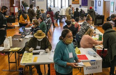Poll workers and voters on Election Day in Lansing, Mich., Nov. 3, 2020. From Wisconsin to North Carolina, the latest surge of the coronavirus is spiraling, especially in battleground states. (Bryan Denton/The New York Times) XNYT344 XNYT344 XNYT344