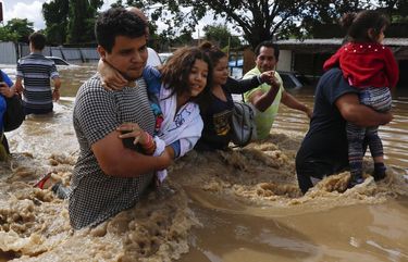 People help each other wade through a flooded street in the aftermath of Hurricane Eta in Jerusalen, Honduras, Thursday, Nov. 5, 2020. The storm that hit Nicaragua as a Category 4 hurricane on Tuesday had become more of a vast tropical rainstorm, but it was advancing so slowly and dumping so much rain that much of Central America remained on high alert. (AP Photo/Delmer Martinez) MXEV109 MXEV109