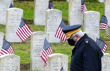 Army Veteran Bill MacCully, who served in Vietnam, walks past the grave markers while visiting the Veterans Memorial Cemetery at Evergreen Washelli in Seattle on Veterans Day, November 11, 2020. The yearly placement of flags is to honor the veterans and their families for their service. MacCully is a member of The Evergreen Washelli Veterans Memorial  Board who welcomes the participation of younger generations, who help continue to recognize the significance of Veterans Day in the United States.  215602