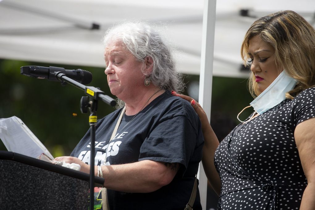 Elaine Simons holds back tears while talking about her foster son, Jesse Sarey, as she is comforted by Sonia Joseph, right, during the Next Steps Rally in June at Judkins Park, Seattle. Sarey was killed in 2019 by Auburn police Officer Jeffrey Nelson, who has been involved in three fatal shootings while on duty. Joseph’s son, Giovonn Joseph-McDade, was killed by Kent police in 2017. (Bettina Hansen / The Seattle Times)
