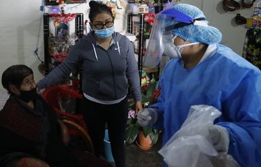 Dr. Delia Caudillo, right, gives medical guidance to 82-year-old Modesta Caballero, accompanied by her granddaughter, after a medical team tested Caballero for COVID-19 at her home in the Venustiano Carranza borough of Mexico City, Thursday, Nov. 19, 2020. (AP Photo/Rebecca Blackwell) RLB124 RLB124