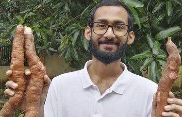 In this Sept. 11, 2020 photo, provided by Sijo Zachariah, Zachariah holds tapioca roots harvested from the farm that he and his father started during coronavirus lockdown in Alappuzha in the southwestern Indian state of Kerala. Guided by a combination of online videos and techniques Zachariah’s grandfather passed down to his father, they began a garden that eventually helped feed 20 neighboring households during the pandemic. (Sijo Zachariah via AP) NYEL601 NYEL601