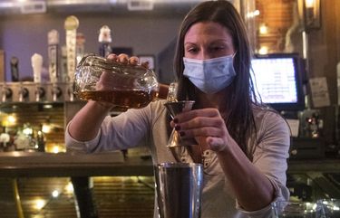 Bartender Kellie Mottiqua prepares drinks, Monday, Nov. 23, 2020, at Bridgetown Taphouse in Ambridge, Penn. Earlier in the day, with the state’s surge in new COVID-19 cases, hospitalizations and deaths, Gov. Tom Wolf and Health Secretary Rachel Levine announced a series of orders and advisories, including a stay-at-home advisory, and an order suspending all alcohol sales in bars, restaurants or catered events during the night before Thanksgiving. (Emily Matthews/Pittsburgh Post-Gazette via AP) PAPIT165 PAPIT165