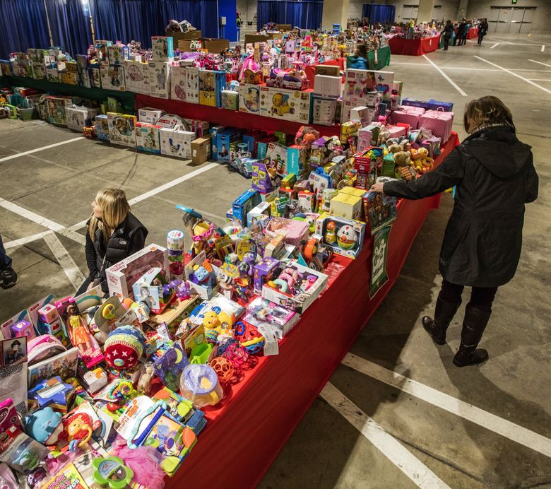 Volunteers sort toys during a collection by The Salvation Army in 2016. Due to COVID-19, many homeless service providers have changed the way they accept gift donations during this year’s holiday season.  (Steve Ringman / The Seattle Times, file)