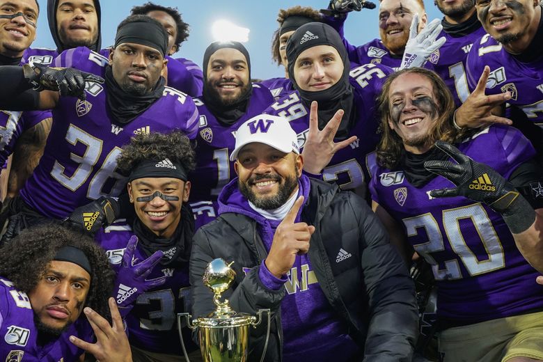 JImmy Lake and his defensive unit pose with the Apple Cup trophy after Washington defeated WSU 31-13 on Friday, November 29, 2019. (Dean Rutz / The Seattle Times)