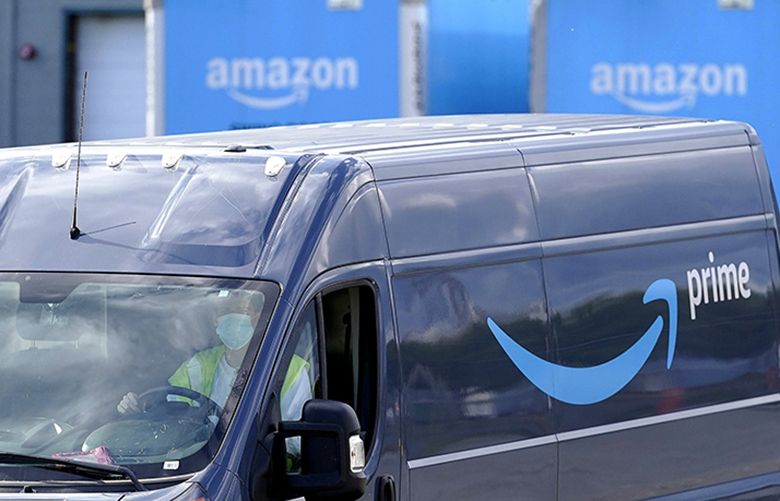 In this file photo dated Thursday, Oct. 1, 2020, an Amazon Prime logo appears on the side of a delivery van as it departs an Amazon Warehouse location in Dedham, USA. The EU’s executive commission, the bloc’s top antitrust enforcer, said Tuesday Nov. 10, 2020, that the charges have been sent to Amazon, accusing the e-commerce giant of using data to gain an unfair advantage over merchants using its platform. (Steven Senne / The Associated Press)