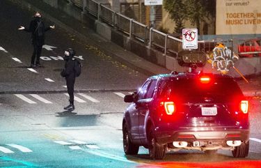 A protester from Every Night Direct Demonstration, or ENDD, blocks the police car as the groups heads down Denny Way on election night on Tuesday, Nov. 3, 2020. 215549