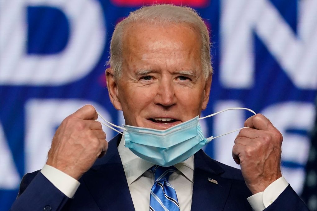 Democratic presidential candidate former Vice President Joe Biden takes off his face mask as he arrives to speak, Wednesday, Nov. 4, 2020, in Wilmington, Del. (AP Photo/Carolyn Kaster)