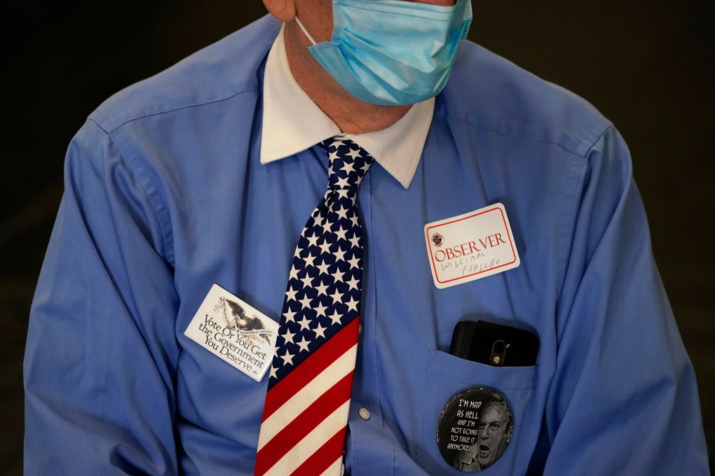 An observer watches a polling place on Election Day in Las Vegas. Election officials in key battleground states pushed back on claims by the Trump campaign that Republican poll watchers were being improperly denied access to observe the counting of ballots, saying Thursday that rules were being followed and they were committed to transparency. (AP Photo/John Locher, File)