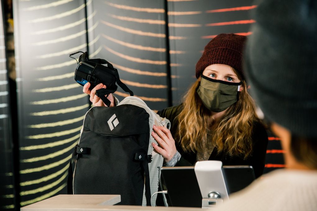 Melissa Garrett rings up a customer for an avalanche transceiver and backcountry ski pack in November 2020 at evo’s Seattle flagship store. (Cameron Munn)
