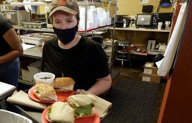 Lindsey Hart carries out sandwiches to sit-in diners at the San Francisco Deli in Redding, Calif., on Dec. 3. (AP Photo/Rich Pedroncelli)
