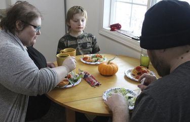 Airis Messick, left, and Brian Messick, right, eat lunch with this 9-year-old son, Jayden, at their apartment in Anchorage, Alaska, on Wednesday, Nov. 11, 2020. Messick and her husband have had to turn to food banks after both lost their jobs in the economic downturn caused by the coronavirus pandemic. Airris, who just turned 30, found work in August, ironically, at the state unemployment office. â€œI hear peopleâ€™s stories all day,â€ she says. â€œI listen to moms cry about not having money to take care of their kids. My heart aches for the people who get denied.â€ (AP Photo/Mark Thiessen) NY810 NY810