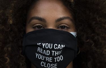 FILE – In this Monday, Dec. 7, 2020, file photo, Daisha Graf, 34, pauses for photos wearing a face mask with a message that reads “If you can read this, you’re too close,” in Los Angeles. Virtually every state is reporting surges in cases and deaths. (AP Photo/Jae C. Hong, File) NYAG203 NYAG203