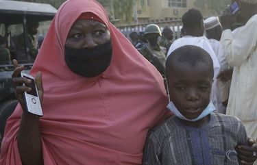 A mother is reunited with her freed schoolboy son who was among the kidnapped students in Katsina, Nigeria Friday, Dec. 18, 2020. More than 300 schoolboys kidnapped last week in an attack on their school in northwest Nigeria have arrived in the capital of Katsina state to celebrate their release. The boys were abducted one week ago from the all-boys Government Science Secondary School in Kankara in Katsina state village. (AP Photo/Sunday Alamba) XSA402 XSA402