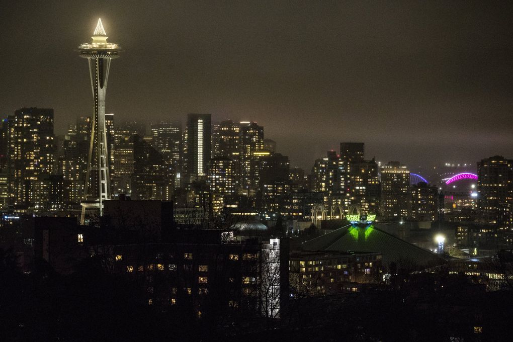 The new sign atop Climate Pledge Arena is lit up for the first time on Tuesday evening, Dec. 8, 2020. (Amanda Snyder / The Seattle Times)