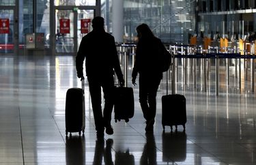 People walk through a deserted check-in hall at the airport in Munich, Germany, Saturday, Dec. 26, 2020 as Germany continues its second lockdown to avoid the further outspread of the coronavirus. (AP Photo/Matthias Schrader) MAS101 MAS101