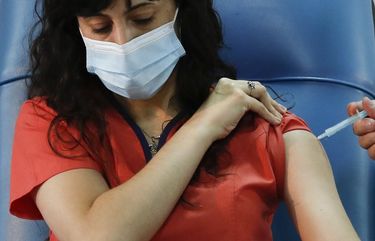 Dr. Estefania Zevrnja gets a shot of Russia’s Sputnik V vaccine for COVID-19 at Dr. Pedro Fiorito Hospital in Avellaneda, Argentina, Tuesday, Dec. 29, 2020. (AP Photo/Natacha Pisarenko)