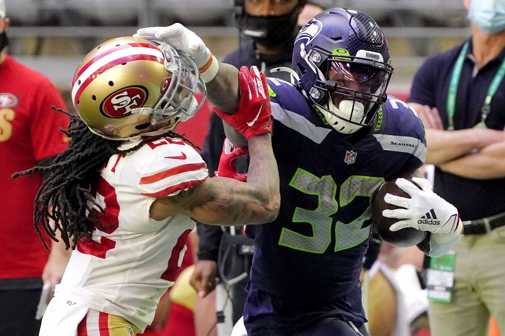 Seahawks running back Chris Carson (32) stiff arms San Francisco 49ers cornerback Jason Verrett in the first half Sunday in Glendale, Ariz. (Rick Scuteri / The Associated Press)