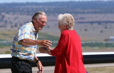 FILE – In this July 11, 2018, file photo, rancher Dwight Hammond Jr., left, is embraced by his wife, Susie Hammond, after arriving by private jet at the Burns Municipal Airport in Burns, Ore. Hammond and his son Steven, convicted of intentionally setting fires on public land in Oregon, were pardoned by President Donald Trump. The federal government has proposed awarding grazing allotments to the Hammonds, whose case sparked the takeover of a federal wildlife refuge by right-wing extremists in 2016. (Beth Nakamura/The Oregonian via AP, File) ORPOR101 ORPOR101