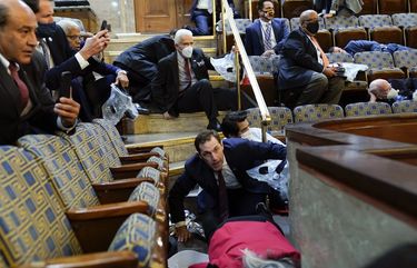 People shelter in the House gallery as protesters try to break into the House Chamber at the U.S. Capitol on Wednesday, Jan. 6, 2021, in Washington. (AP Photo/Andrew Harnik) 