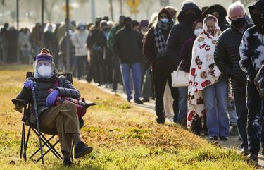 Florence Mullins, 89, sits in a chair as a family member holds her place in a long line to receive the COVID-19 vaccine at Fair Park on Monday, Jan. 11, 2021, in Dallas. Dallas County launched its first “mega” public COVID-19 vaccination site Monday at Fair Park. (Smiley N. Pool/The Dallas Morning News via AP) TXDAM229 TXDAM229