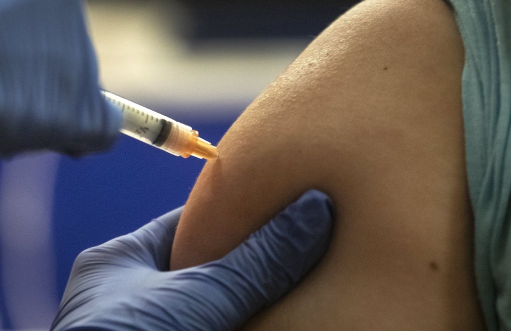 Medical assistant Leovelyn Tamayo injects an Asian Counseling and Referral Service worker with the Moderna vaccine at the International Community Health Services Holly Park Medical Clinic in Seattle. (Steve Ringman / The Seattle Times)