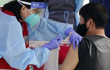 FILE – In this Jan. 13, 2021, file photo, health care workers receive a COVID-19 vaccination at Ritchie Valens Recreation Center, Wednesday, Jan. 13, 2021, in Pacoima, Calif. The rapid expansion of vaccinations to senior citizens across the U.S. has led to bottlenecks, system crashes and hard feelings in many states because of overwhelming demand for the shots. (AP Photo/Marcio Jose Sanchez, File) NYAG406 NYAG406