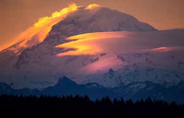 Mt. Rainier looms in this telephoto view from Lake Forest Park during Thursday morning’s sunrise. The mountain appears to be steaming as clouds form and change as the sun hits the mountain as it rises. The Weather forecast is for partly sunny skies on Thursday and Friday with rain in the forecast for Sunday. 
Photographed on January 14, 2021. 

LO  LO  LO   216127