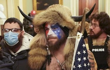 Jacob Anthony Chansley, center, a QAnon adherent known as the Q Shaman, with other supporters of President Donald Trump who swarmed the U.S. Capitol, confronting Capitol Police officers in the building, in Washington, Jan. 6, 2021. They came from around the country, with different affiliations — QAnon, Proud Boys, a few elected officials, many everyday Americans. One allegiance united them. (Erin Schaff/The New York Times) XNYT149 XNYT149