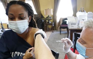 FILE – In this Jan. 12, 2021, file photo, Walgreens pharmacist Chris McLaurin prepares to vaccinate Lakandra McNealy, a Harmony Court Assisted Living employee, with the Pfizer-BioNTech COVID-19 vaccine in Jackson, Miss. The coronavirus vaccines have been rolled out unevenly across the U.S., but some states in the Deep South have had particularly dismal inoculation rates. (AP Photo/Rogelio V. Solis, File) NYAG801 NYAG801