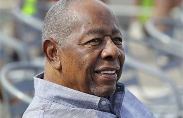 FILE – Baseball Hall of Famer Hank Aaron smiles as he is honored with a street named after him outside CoolToday Park, the spring training baseball facility of the Atlanta Braves, in North Port, Fla., in this Tuesday, Feb. 18, 2020, file photo. Hank Aaron, who endured racist threats with stoic dignity during his pursuit of Babe Ruth but went on to break the career home run record in the pre-steroids era, died early Friday, Jan. 22, 2021. He was 86. The Atlanta Braves said Aaron died peacefully in his sleep. No cause of death was given. (Curtis Compton/Atlanta Journal-Constitution via AP, File) GAATJ201 GAATJ201