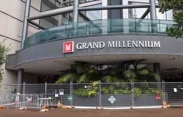 The Grand Millennium hotel, a managed isolation facility, is seen in central Auckland, New Zealand, July, 16, 2020. A traveler and a worker at the quarantine hotel started passing each other notes, including one written on the back of a face mask. Then he delivered a bottle of wine she’d ordered to her room. When he didn’t return 20 minutes later, a security manager sent to investigate found the pair together in what authorities are describing as an inappropriate encounter, one in which physical distancing wasn’t maintained. (Sylvie Whinray/New Zealand Herald via AP)