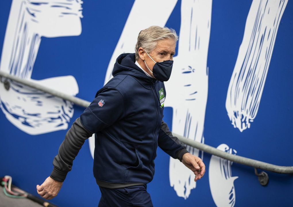 Pete Carroll heads out to the field for Saturday’s playoff game with the Rams. (Dean Rutz / The Seattle Times)